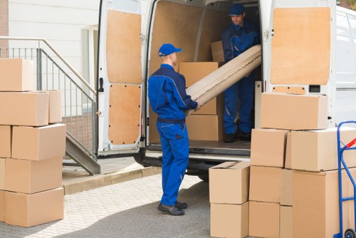 Removal team handling boxes in a Swiss Cottage apartment hallway