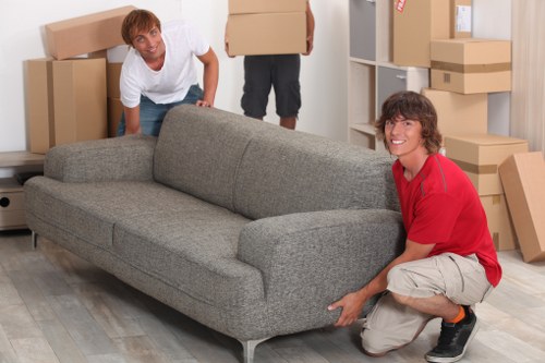Movers carrying furniture through a residential building in Swiss Cottage