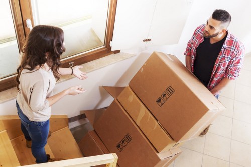 Removal crew transporting household items through a Swiss Cottage residential building
