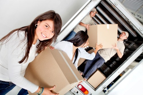 Professional movers transporting boxes and furniture on a local Swiss Cottage move